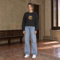 Woman wearing the SERENOS Believing long sleeve in washed black, chest print of a golden sunburst eye circled by the words Believing is seeing