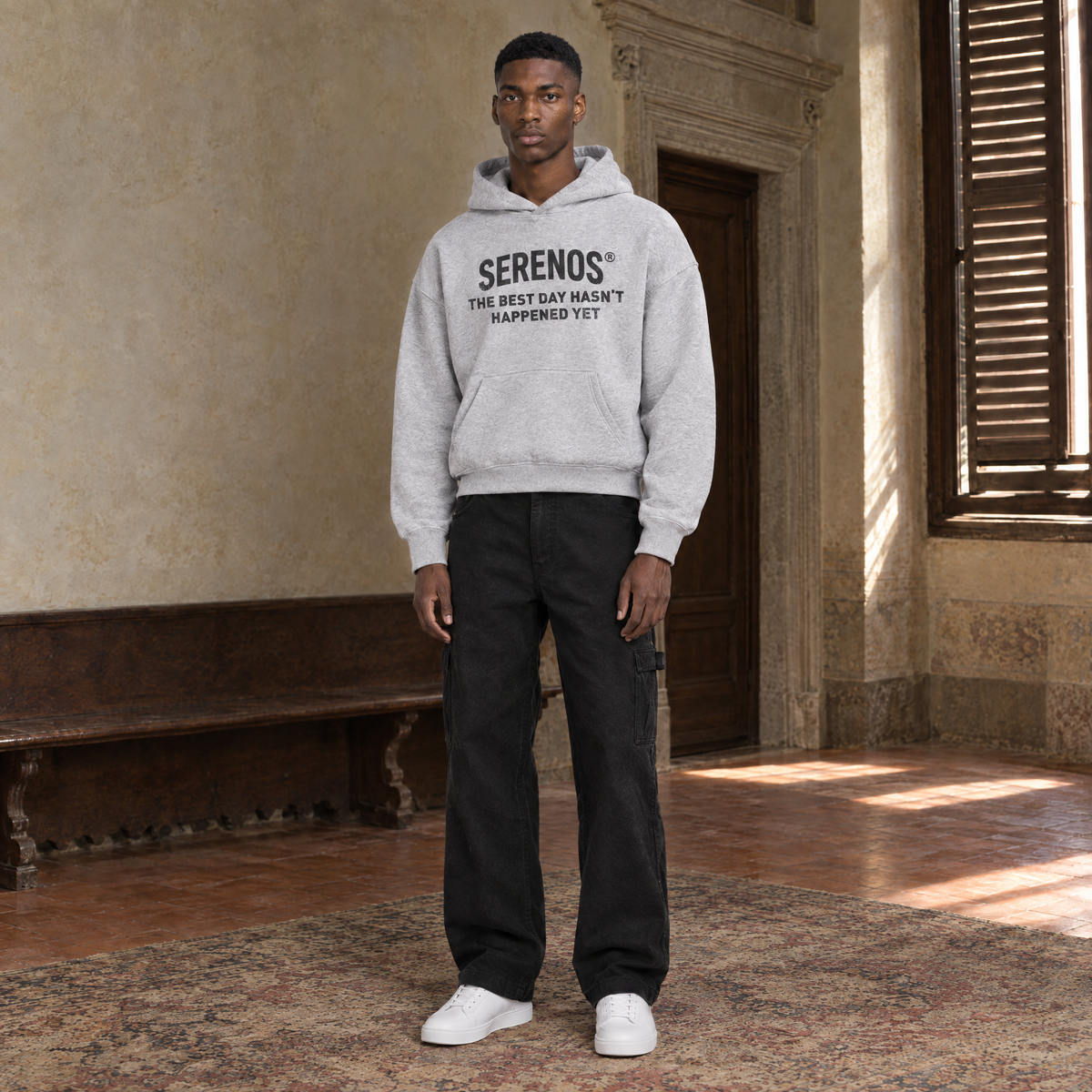 Man wearing the SERENOS Best Day oversized boxy hoodie in flower gray, chest print reading The best day hasn't happened yet, cropped boxy fit