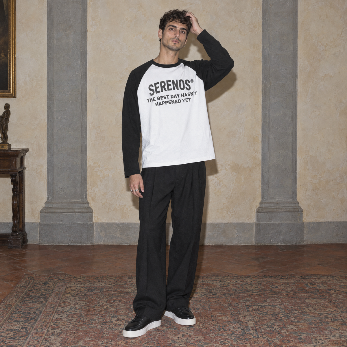 Man wearing the Best Day raglan long sleeve by Serenos in white with black sleeves, front print reading the best day hasn't happened yet