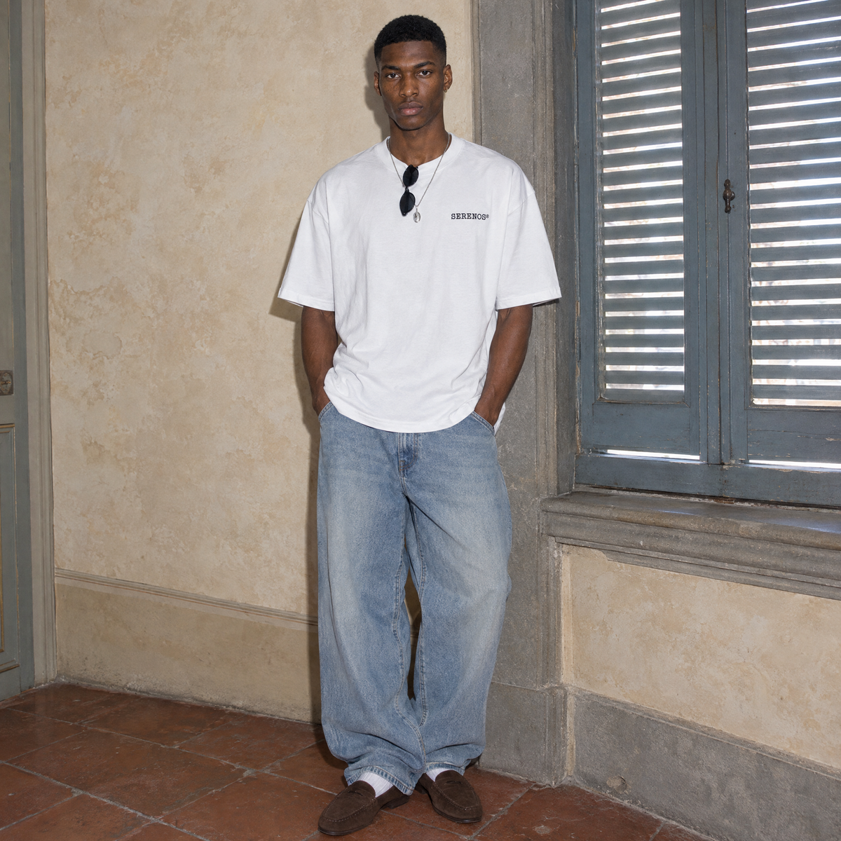 Man wearing the white Brother oversized t-shirt by Serenos, front view with the small Serenos chest logo