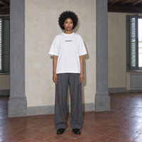 Woman wearing the white Door t-shirt front view with the small burgundy SERENOS chest logo