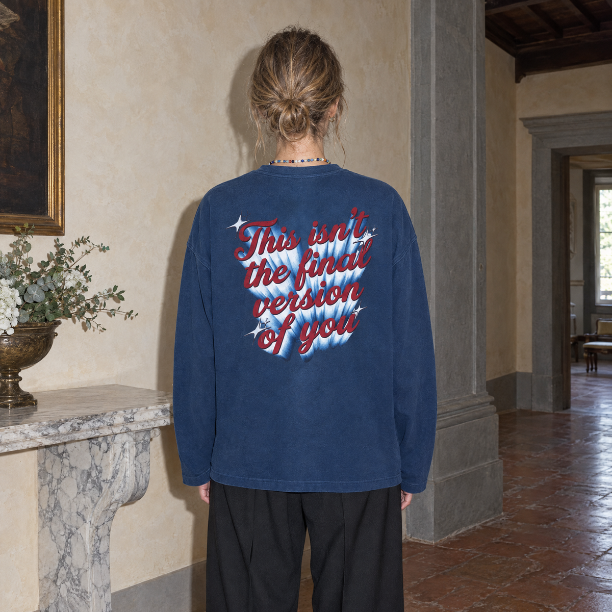 Woman seen from behind wearing the navy SERENOS Final Version long sleeve tee with the This Isn't The Final Version Of You back print