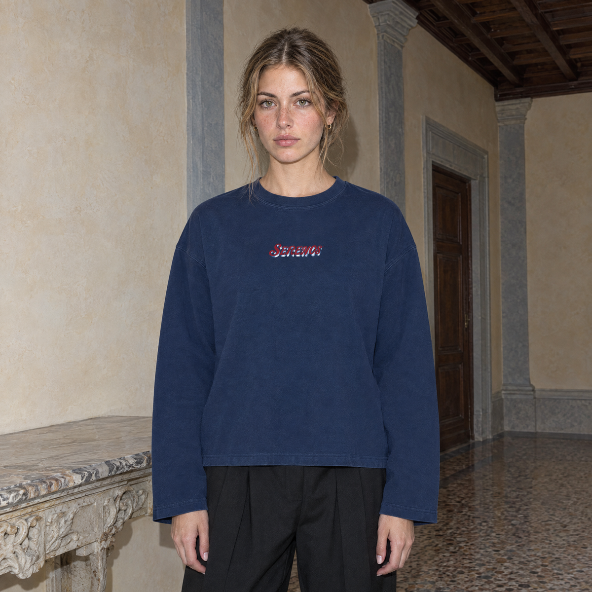 Woman wearing the navy SERENOS Final Version long sleeve tee front view with the red script Serenos chest logo