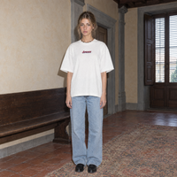 Woman wearing the SERENOS Final Version T-Shirt in white, front view with centred chest logo