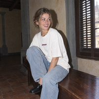 Lifestyle portrait of a woman in the SERENOS Final Version T-Shirt in white inside a Florentine palazzo