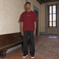 Man wearing the SERENOS Final Version T-Shirt in wine red, front view with centred chest logo
