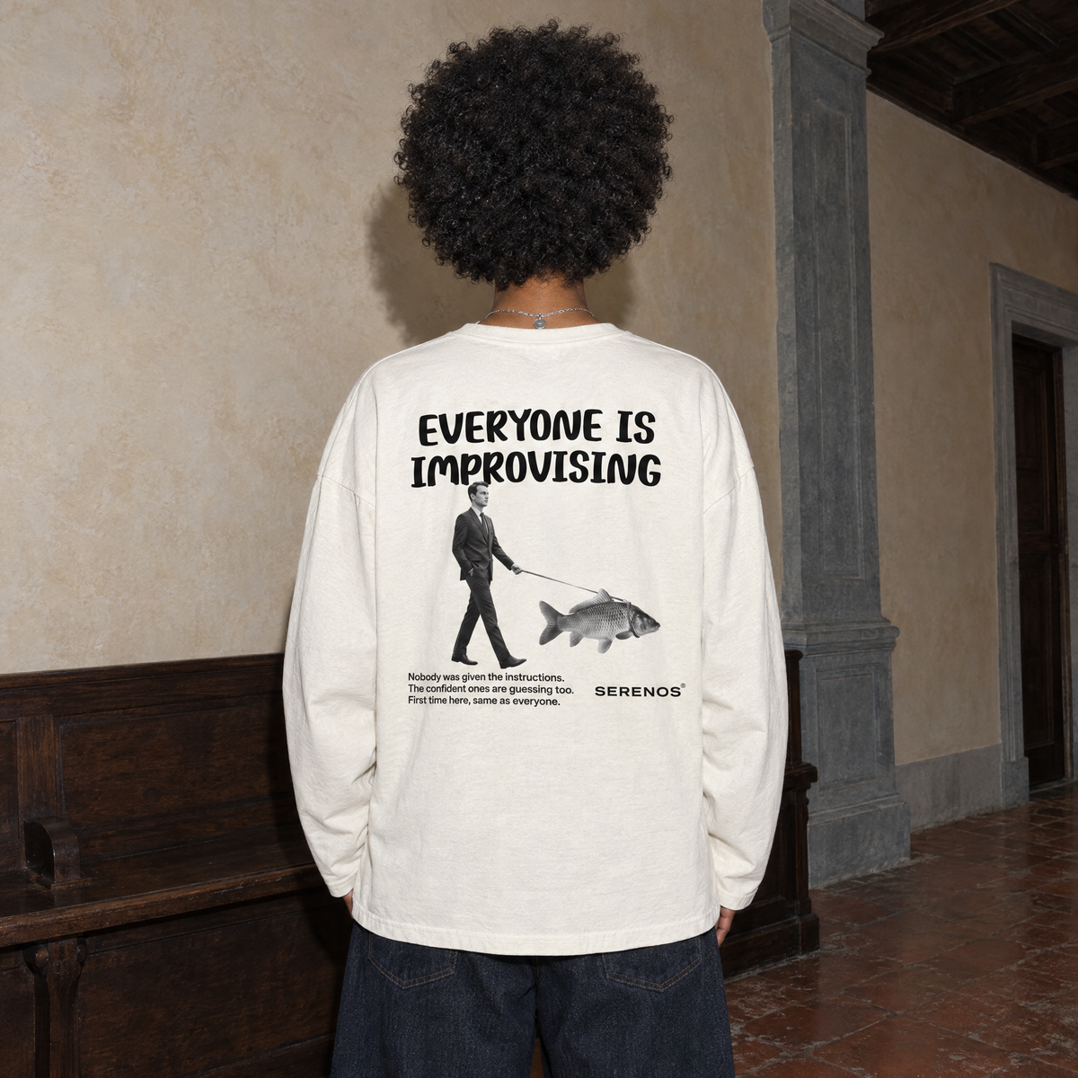 Woman seen from behind wearing the cream SERENOS Improvising long sleeve tee with the Everyone Is Improvising back print