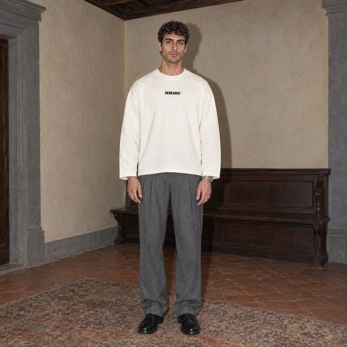 Man wearing the cream SERENOS Improvising long sleeve tee front view with the small centred Serenos chest logo