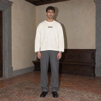 Man wearing the cream SERENOS Improvising long sleeve tee front view with the small centred Serenos chest logo