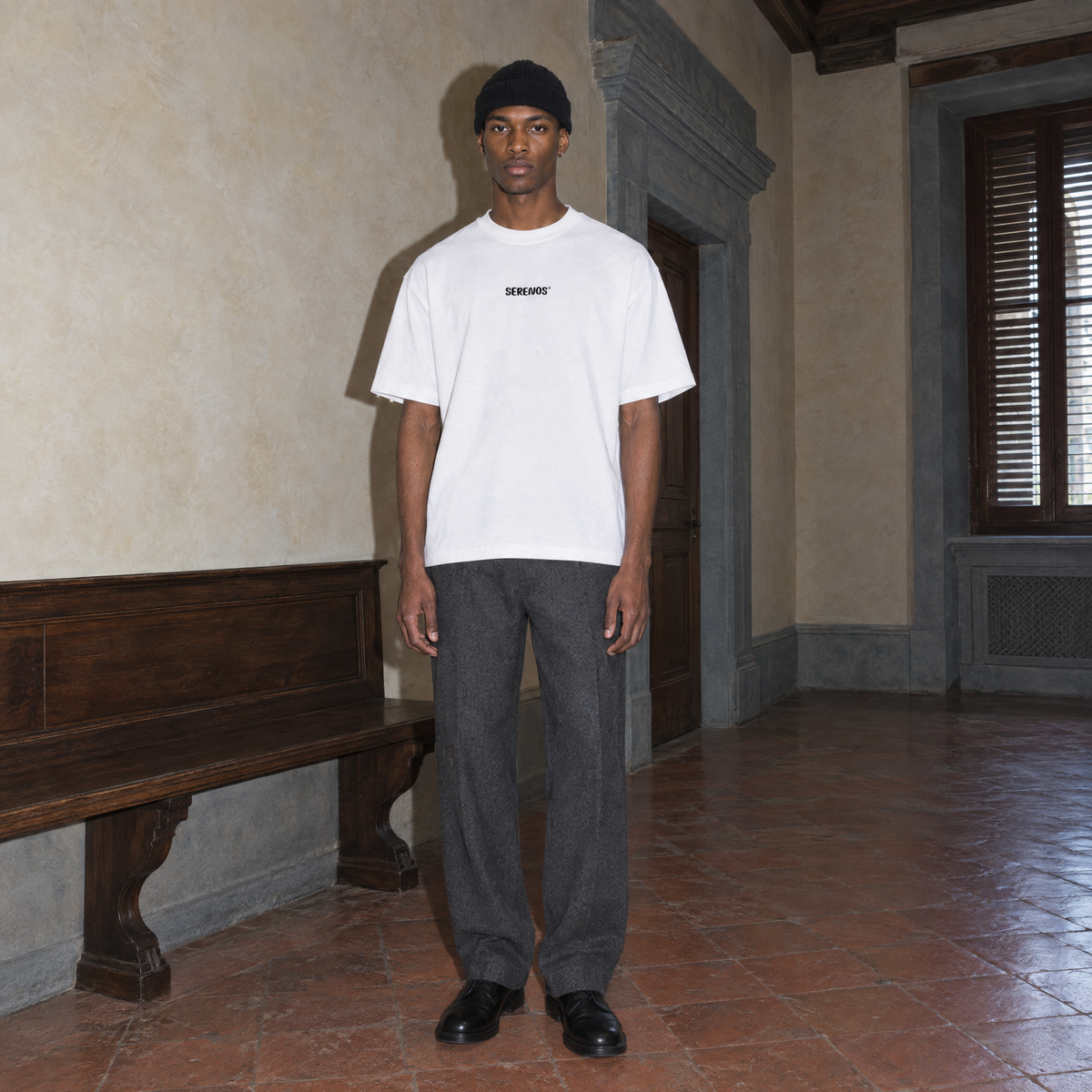 Man wearing the white Improvising t-shirt front view with the small black SERENOS chest logo