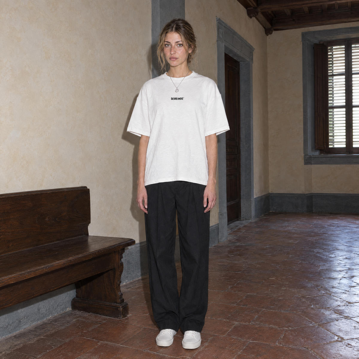 Woman wearing the white Improvising t-shirt front view with the small black SERENOS chest logo