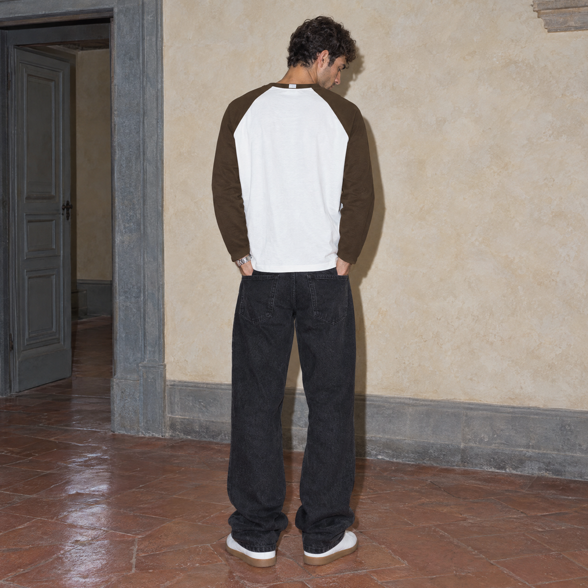 Man seen from behind wearing the Look raglan long sleeve by Serenos, showing the plain white back and coffee brown raglan sleeves