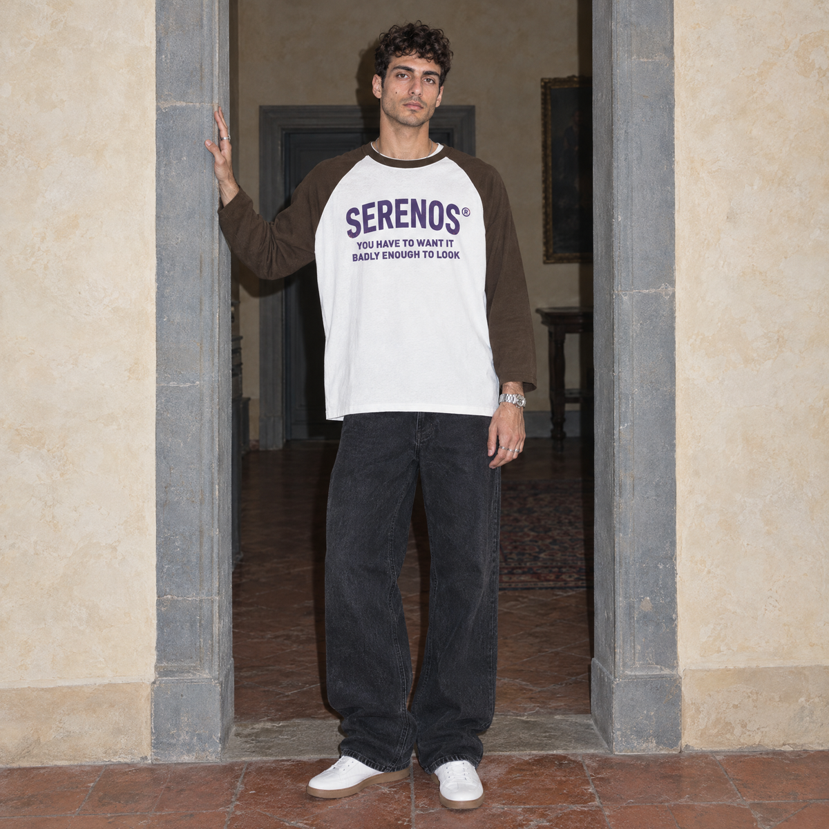Man wearing the Look raglan long sleeve by Serenos in white with coffee sleeves, front print reading you have to want it badly enough to look