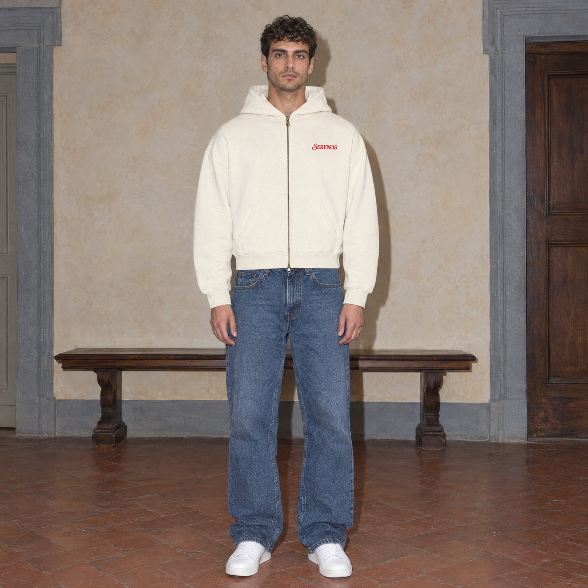 Man wearing the SERENOS Love Full Zip Hoodie in apricot, front view with small red chest logo, cropped boxy fit