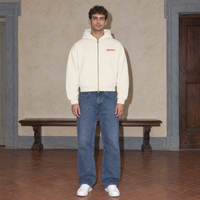 Man wearing the SERENOS Love Full Zip Hoodie in apricot, front view with small red chest logo, cropped boxy fit