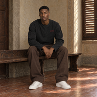 Man sitting on a bench in a Florentine palazzo wearing the SERENOS Love long sleeve in black