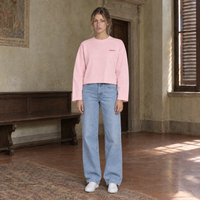 Woman wearing the SERENOS Love long sleeve in pink, front view with the small red chest logo