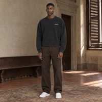 Man wearing the SERENOS Never Happens long sleeve in washed black, front view with the small chest logo
