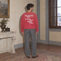 Man wearing the SERENOS Notes Long Sleeve in red, back print reading The kid you were is still in there taking notes