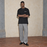 Man wearing the black Notes oversized t-shirt by Serenos, front view with the Serenos we're all in progress chest logo