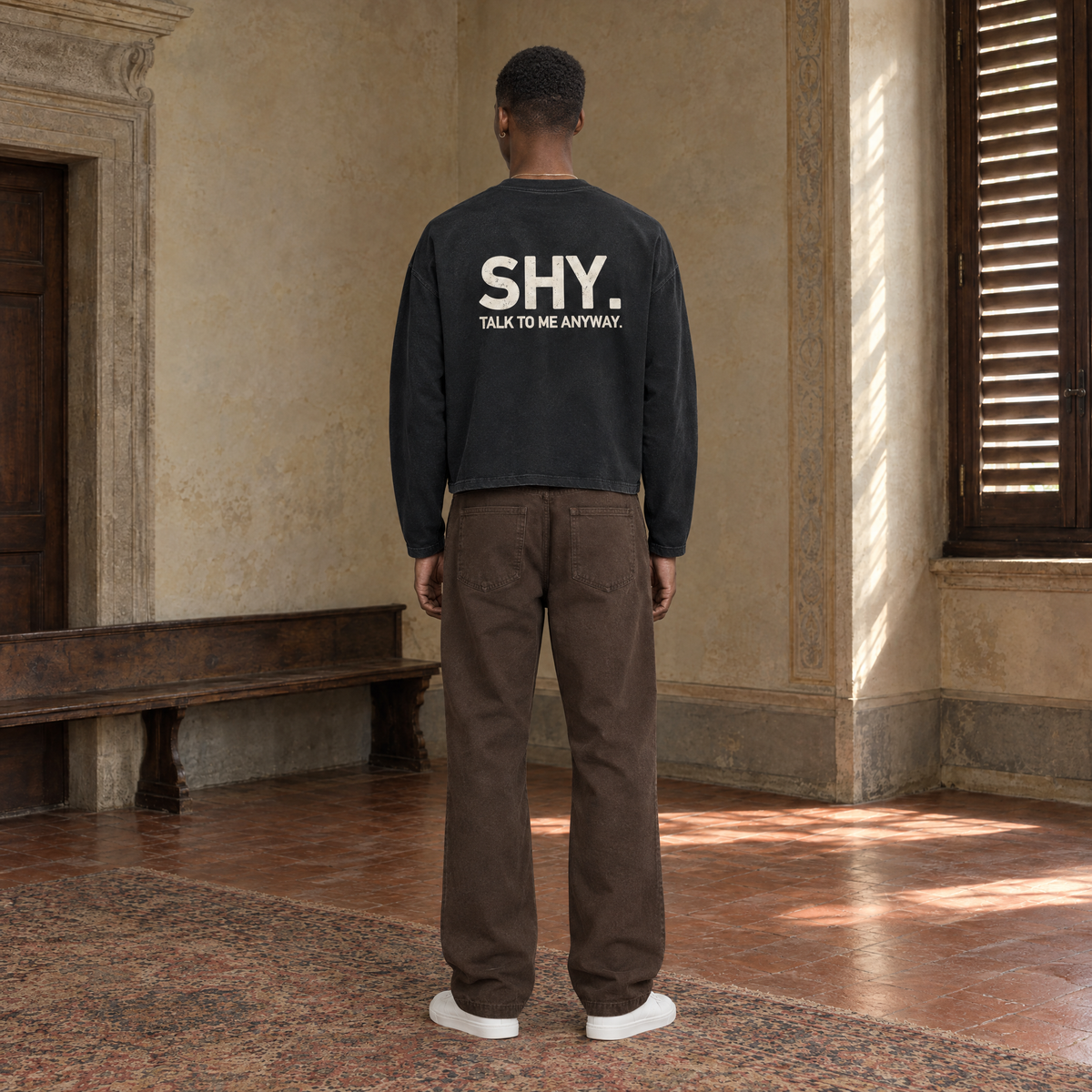 Man seen from behind wearing the SERENOS Shy long sleeve in black, back print reading Shy, talk to me anyway