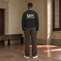 Man seen from behind wearing the SERENOS Shy long sleeve in black, back print reading Shy, talk to me anyway