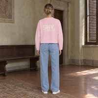 Woman seen from behind wearing the SERENOS Shy long sleeve in pink, back print reading Shy, talk to me anyway