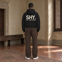 Man seen from behind wearing the SERENOS Shy oversized boxy hoodie in black, back print reading Shy, talk to me anyway