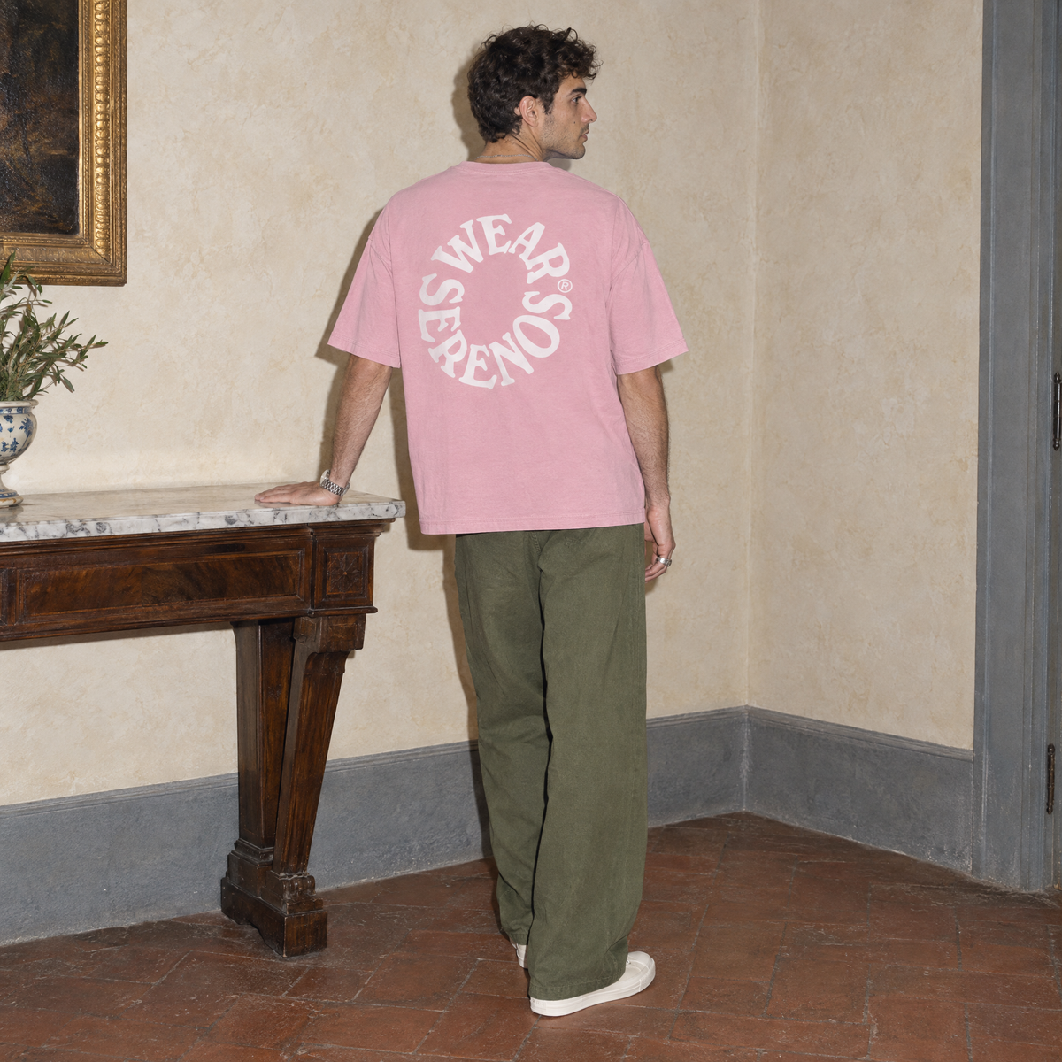 Man seen from behind wearing the pink Spiral oversized t-shirt by Serenos, circular Wear Serenos back print