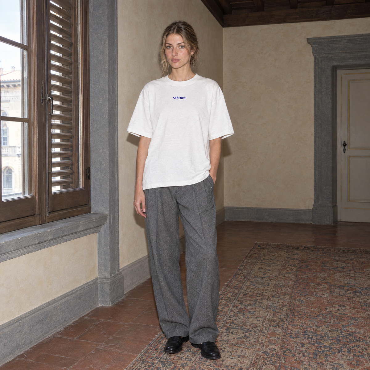 Woman wearing the white Start Over t-shirt front view with the small blue SERENOS chest logo