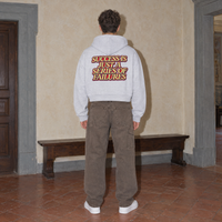 Man wearing the SERENOS Success oversized boxy hoodie in flower gray, seen from behind showing the Success Is Just A Series Of Failures back print, cropped boxy fit