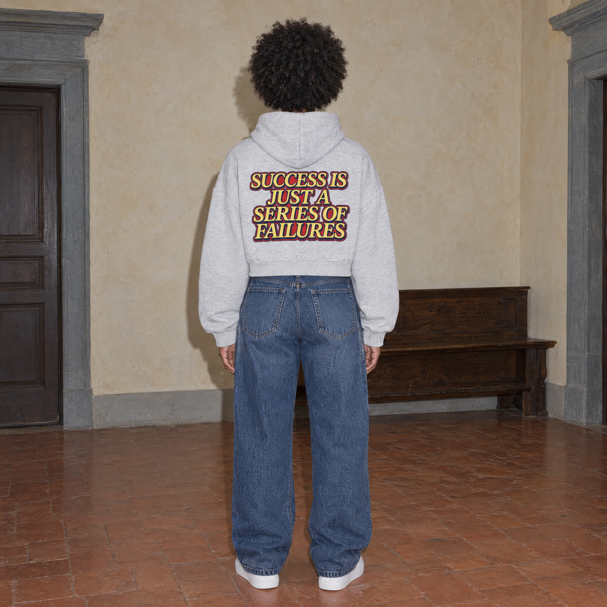 Woman wearing the SERENOS Success oversized boxy hoodie in flower gray, seen from behind showing the Success Is Just A Series Of Failures back print, cropped boxy fit
