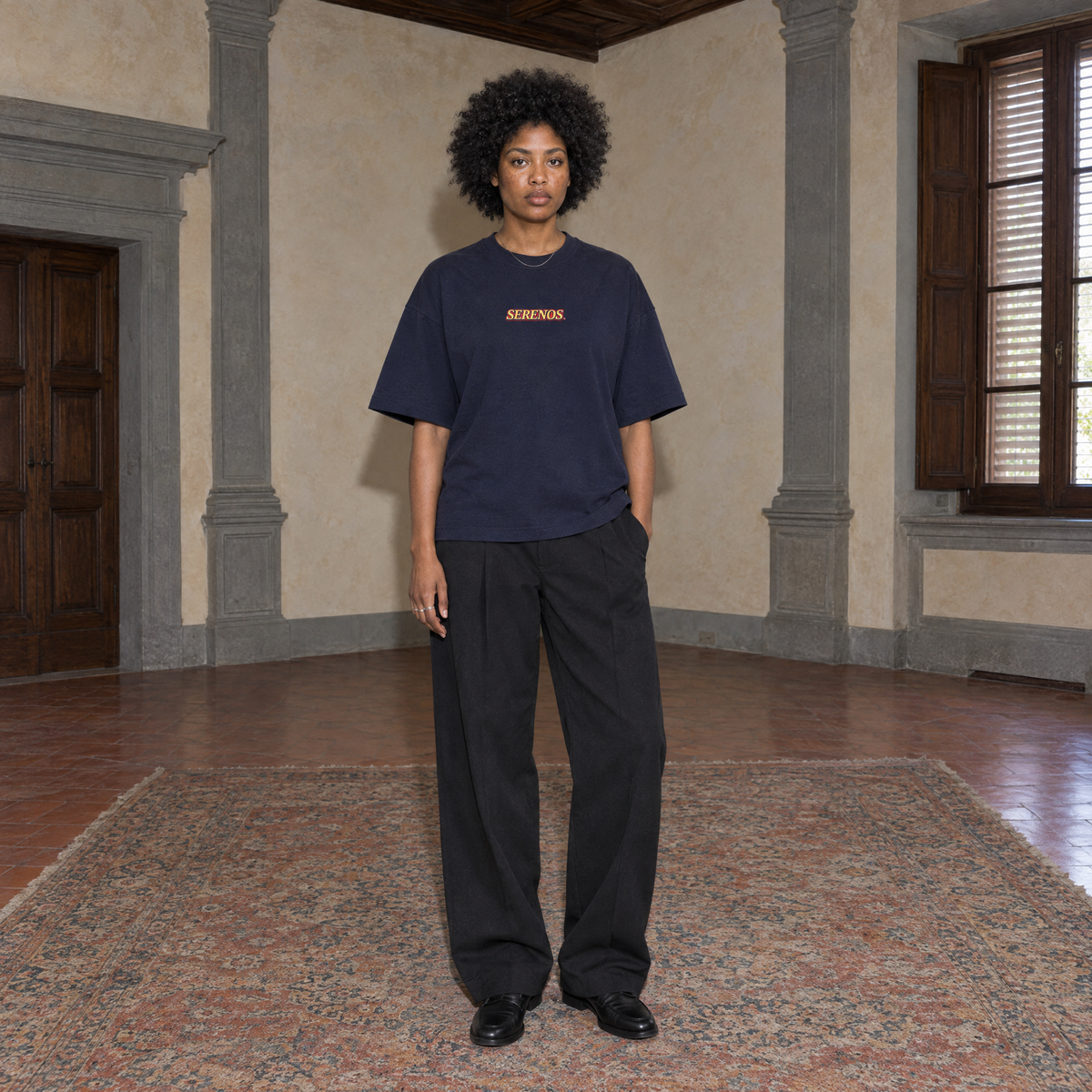 Woman wearing the SERENOS Success T-Shirt in navy blue, front view with centred chest logo