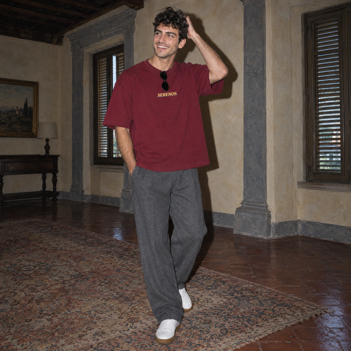 Lifestyle portrait of a man in the SERENOS Success T-Shirt in wine red inside a Florentine palazzo