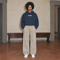Woman wearing the navy SERENOS Sun Above oversized boxy hoodie, front view with the cream Serenos chest wordmark, cropped boxy fit