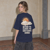 Woman wearing the navy Sun Above oversized boxy t-shirt, seen from behind, back print reading Beyond the clouds, the sun always shines