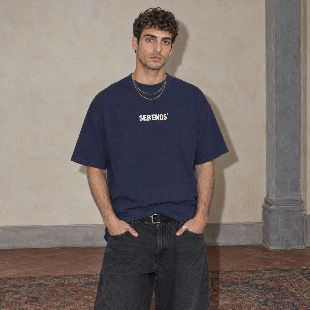 Man wearing the navy Sun Above oversized boxy t-shirt, front view with the Serenos wordmark on the chest