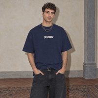 Man wearing the navy Sun Above oversized boxy t-shirt, front view with the Serenos wordmark on the chest