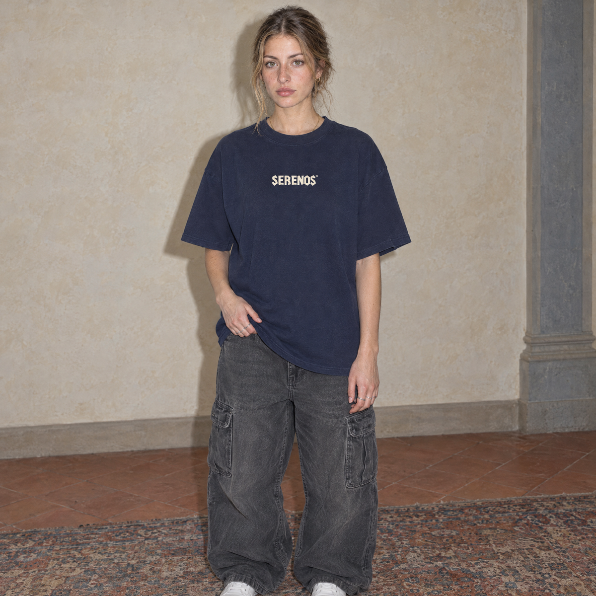 Woman wearing the navy Sun Above oversized boxy t-shirt, front view with the Serenos wordmark on the chest