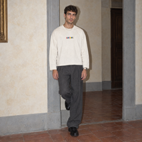 Man wearing the cream Therapist long sleeve by Serenos, front view with the multicoloured Serenos chest logo