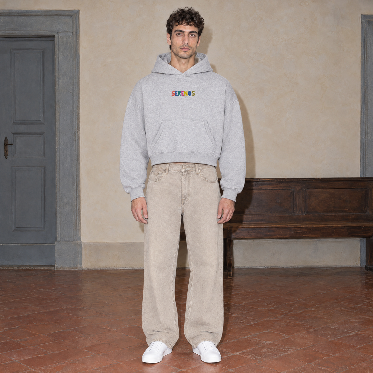 Man wearing the SERENOS Therapist oversized boxy hoodie in flower gray, front view with the small multicoloured chest wordmark