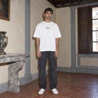 Man wearing the white Therapist t-shirt front view with the small multicoloured SERENOS chest logo