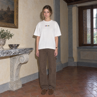 Woman wearing the white Therapist t-shirt front view with the small multicoloured SERENOS chest logo