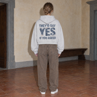 Woman wearing the SERENOS Yes oversized boxy hoodie in flower gray, seen from behind showing the They'd Say Yes If You Asked denim back print, cropped boxy fit