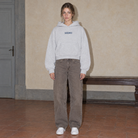 Woman wearing the SERENOS Yes oversized boxy hoodie in flower gray, front view with the centred denim SERENOS chest logo, cropped boxy fit
