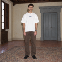 Man wearing the white Yes t-shirt front view with the small denim-blue SERENOS chest logo