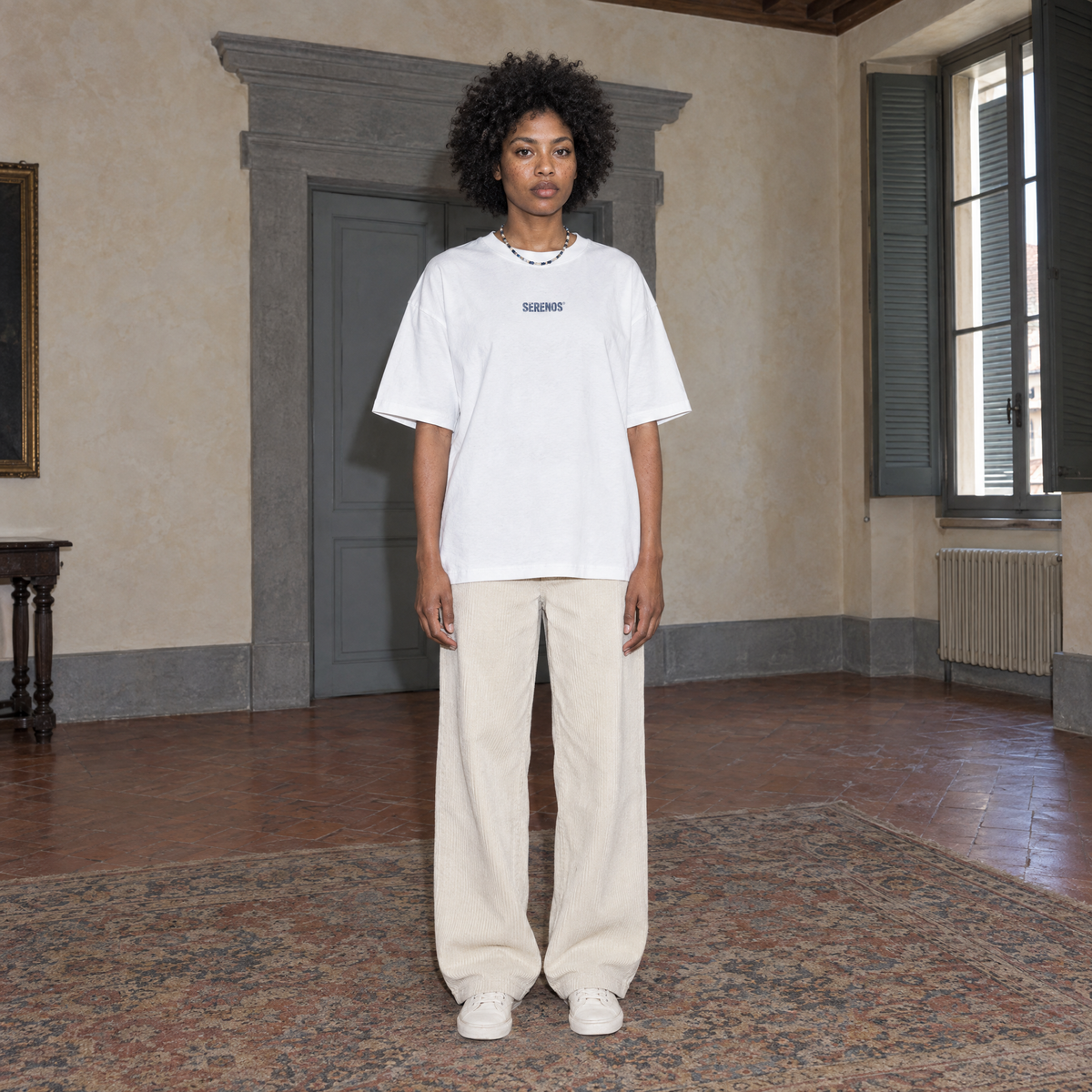 Woman wearing the white Yes t-shirt front view with the small denim-blue SERENOS chest logo