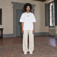 Woman wearing the white Yes t-shirt front view with the small denim-blue SERENOS chest logo