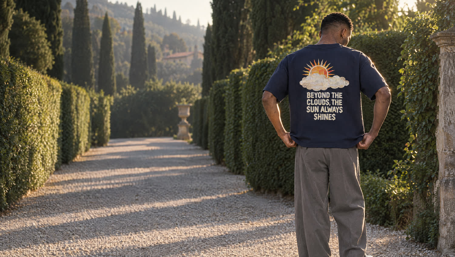 A man alone on a gravel path, wearing the navy Sun Above t-shirt by Serenos